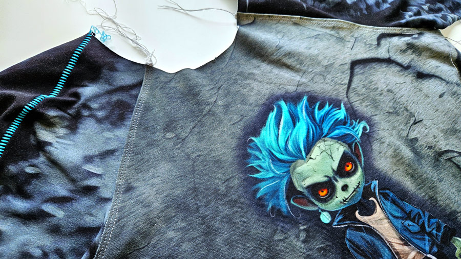 Raglanärmel wird an ein Shirt mit Negativapplikation und dekorativer Flachnaht Overlock angenäht.