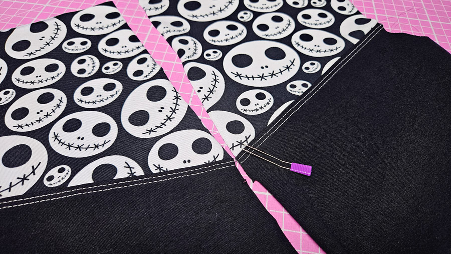 Die Teilungen am Rückenteil eines Shirts werden mit einer Gabelnadel passend gesteckt.