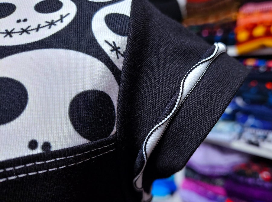 Detailaufnahme vom Ärmel eines Shirts mit dekorativer Wave-Flachnaht als Saumabschluss.