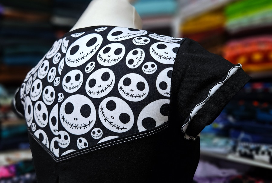 Detailansicht der Rückseite eines Shirts mit Musterstoff, Covernähten und Wave-Flachnaht am Ärmel.
