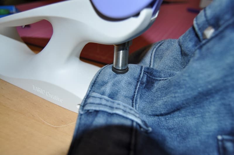 Mit dem Vario Creative Tool wird ein Loch seitlich in den Bund der Upcycling-Tasche gestanzt.