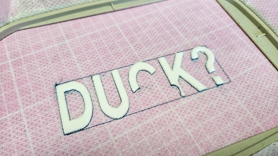 Freigelegter Stickschaum in Form des Schriftzugs „DUCK?“ für eine Trapunto-Stickerei.
