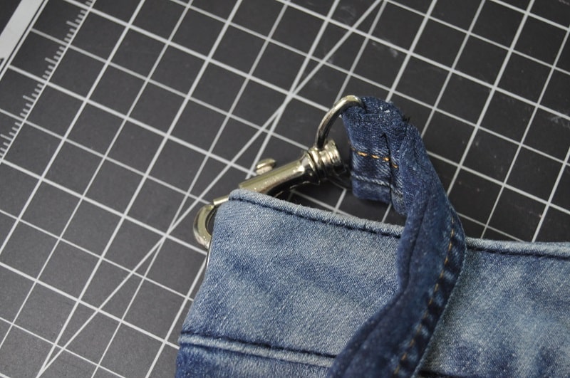 Detailaufnahme des mit Karabiner befestigten Jeansträgers an der fertigen Upcycling-Tasche.