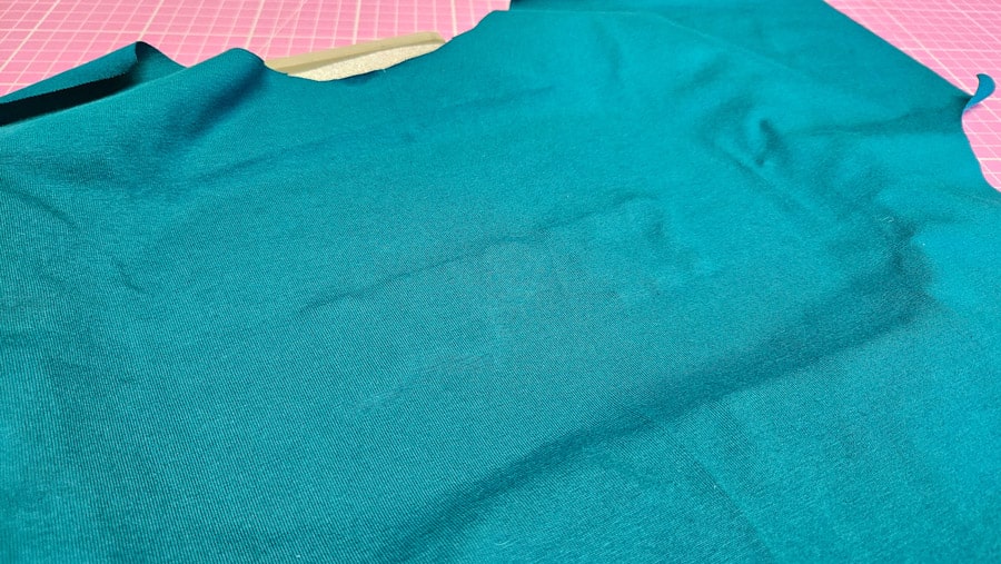 Türkisfarbenes Shirt-Vorderteil liegt glatt über dem Stickrahmen für die anschließende Trapunto-Stickerei.