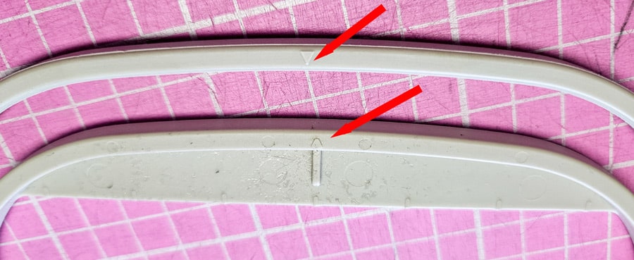 Stickrahmen mit markierten Ausrichtungspunkten an Innen- und Außenrahmen.