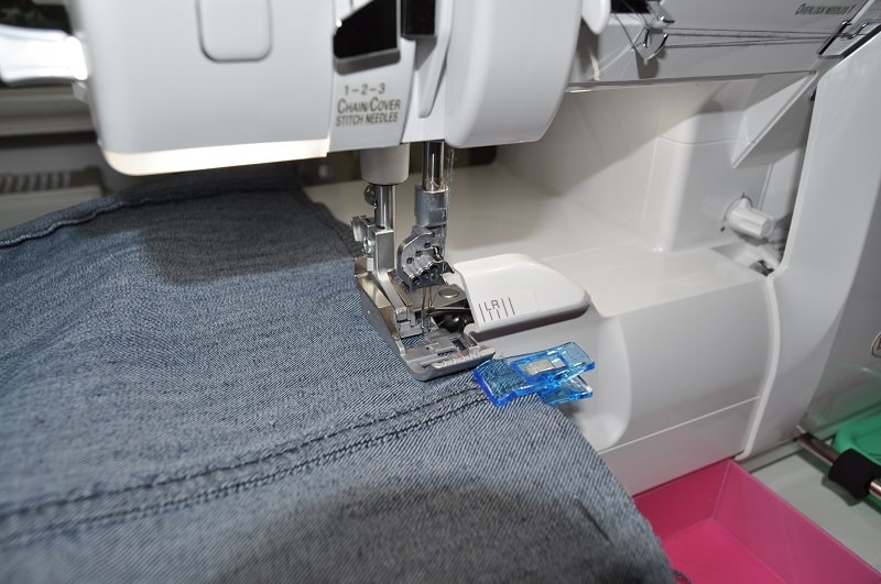 Vorder- und Rückteil des gekürzten Jeansrocks werden mit der Overlock zusammengenäht.