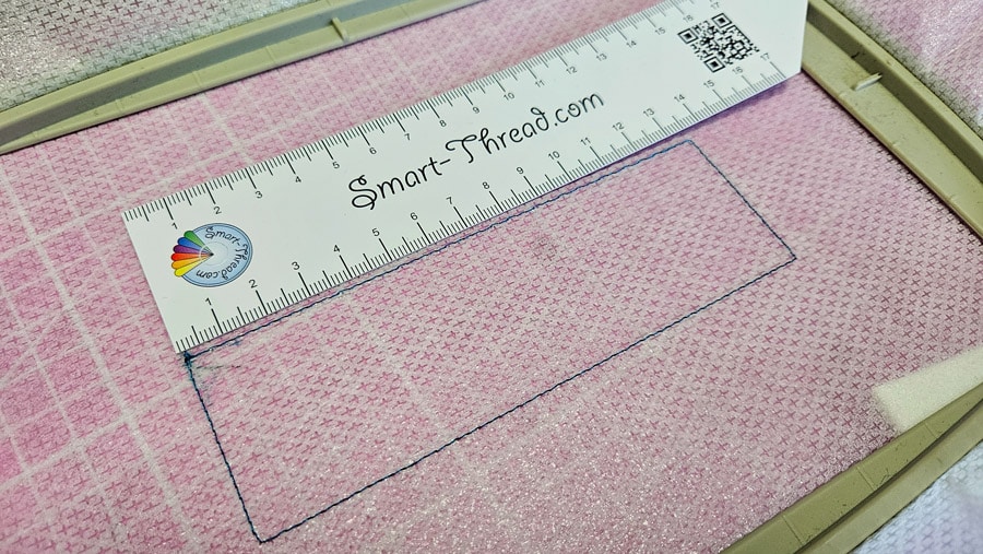 Gestickte Platzierungslinie wird mit einem Lineal für den Zuschnitt des Stickschaums ausgemessen.
